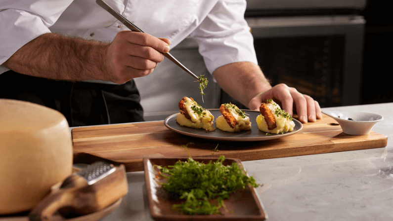 Cropped photo Close-up hands of male cook adding greens finishing dish, decorating meal in the end. gastronomy, food, nutrition, cafe concept